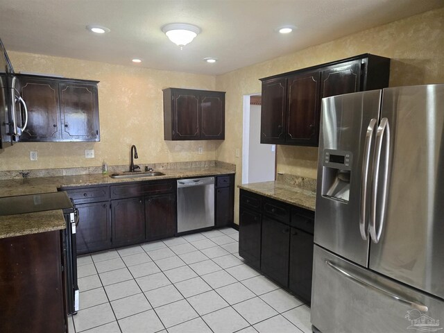 3285 Fairview Dr, Crestview, FL 32539 - kitchen with light tile patterned flooring, dark brown cabinets, appliances with stainless steel finishes, a sink, and a textured wall