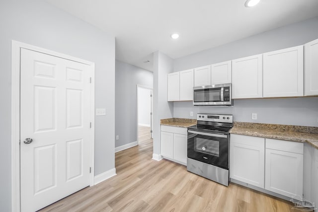 kitchen featuring stainless steel appliances, white cabinets, and light wood-type flooring