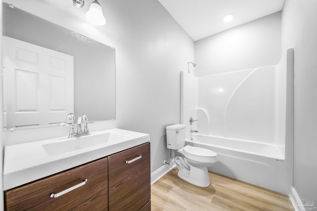 full bathroom featuring hardwood / wood-style flooring, toilet, vanity, and  shower combination