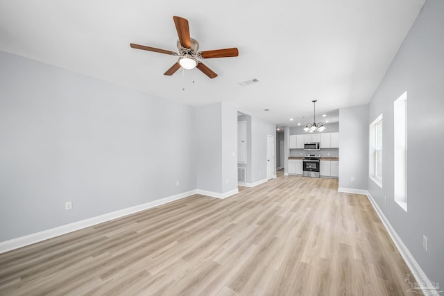 unfurnished living room with ceiling fan with notable chandelier and light hardwood / wood-style flooring