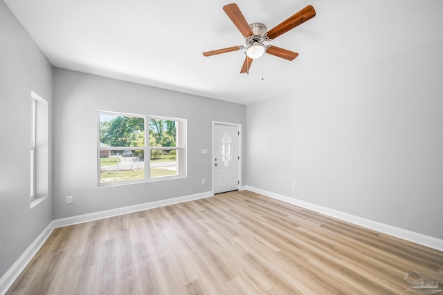 empty room with ceiling fan and light hardwood / wood-style flooring