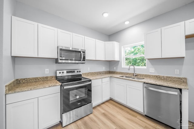 kitchen featuring white cabinetry, appliances with stainless steel finishes, sink, and light wood-type flooring