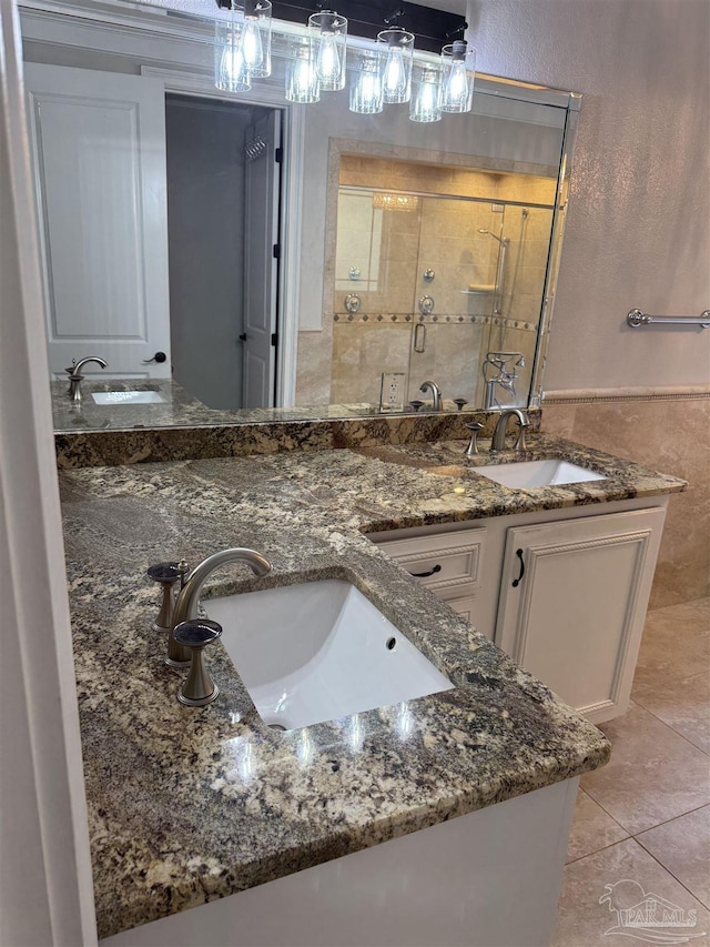 bathroom featuring vanity, tile patterned floors, a shower with door, and tile walls