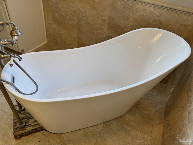 bathroom featuring tile patterned flooring, a bath, and tile walls