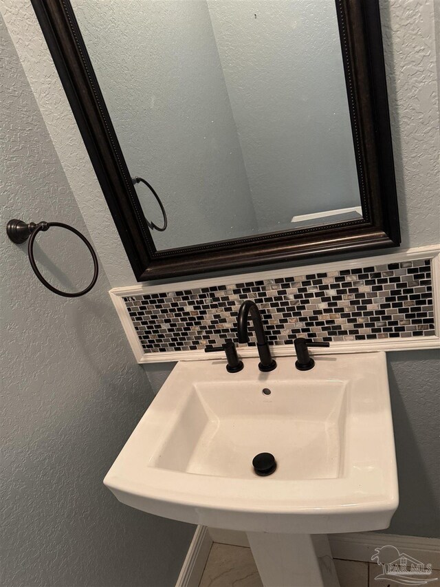 bathroom featuring decorative backsplash and sink