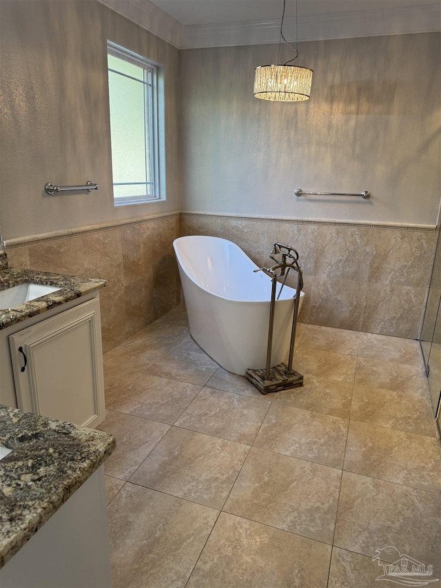 bathroom with a bathtub, vanity, tile walls, and ornamental molding