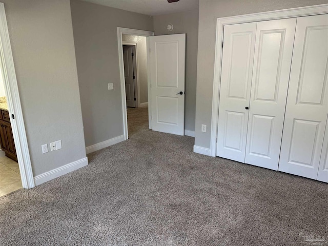 unfurnished bedroom with light carpet and a closet