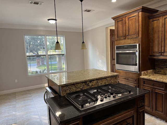 kitchen with a kitchen island, stainless steel appliances, and ornamental molding