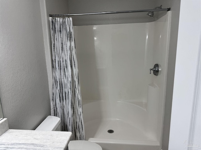 bathroom featuring toilet, vanity, and a shower with shower curtain