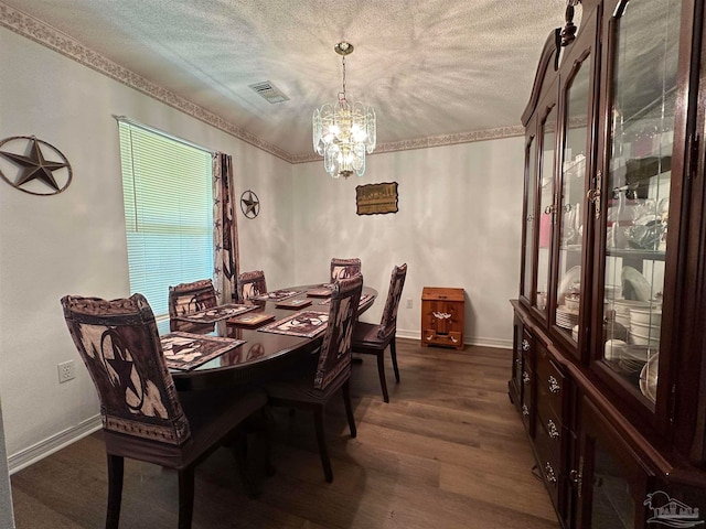 dining room with a textured ceiling, hardwood / wood-style floors, and a chandelier