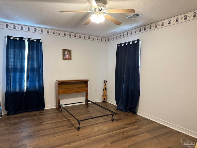 bedroom featuring hardwood / wood-style flooring, a textured ceiling, and ceiling fan