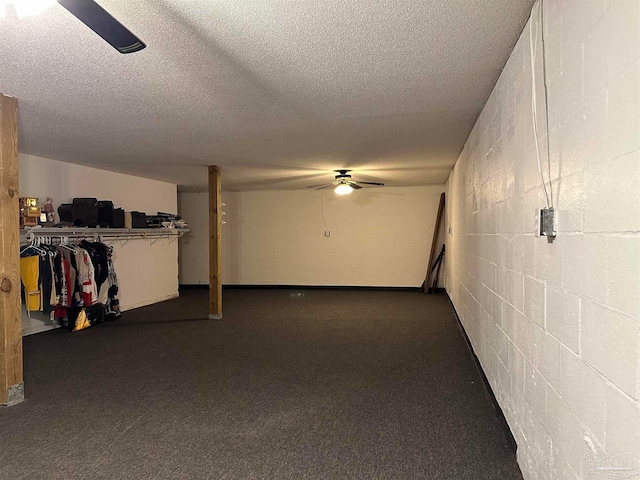 interior space featuring dark colored carpet, a textured ceiling, and ceiling fan