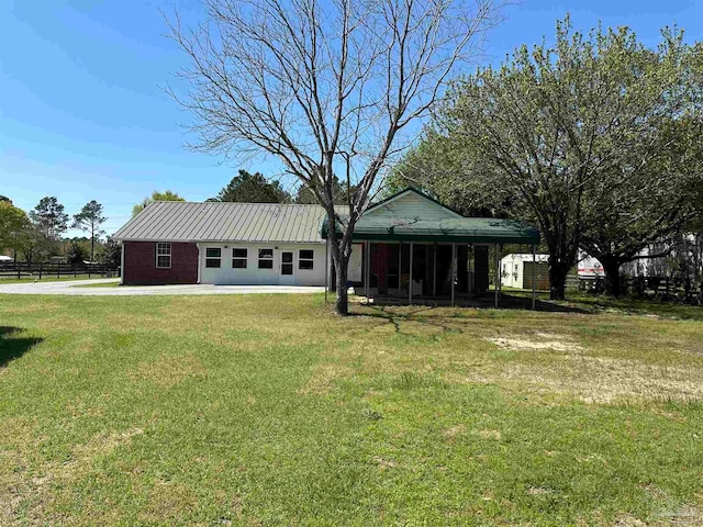 rear view of property with a garage and a yard