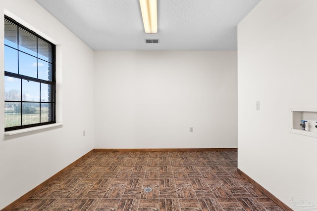 unfurnished room featuring a textured ceiling and dark wood-type flooring