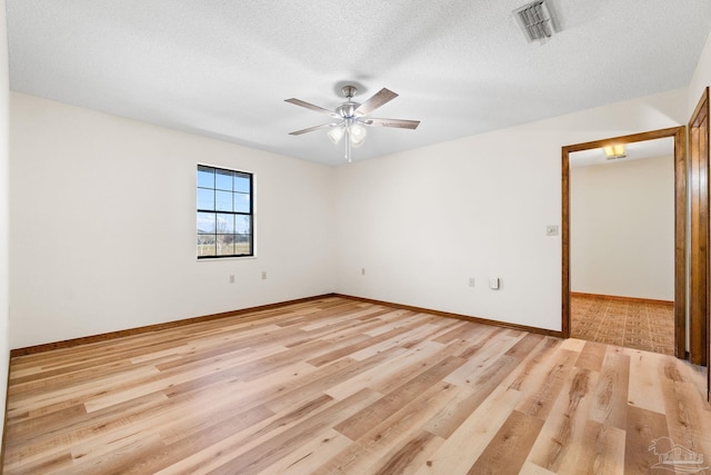 unfurnished room featuring a textured ceiling, light wood-type flooring, and ceiling fan