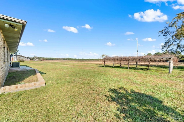 view of yard featuring central AC unit and a rural view