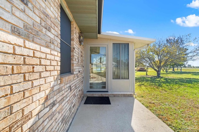 property entrance featuring a yard and a patio