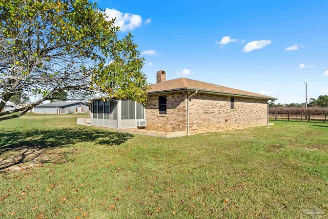 back of property with a sunroom and a yard