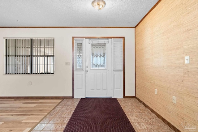 entrance foyer with hardwood / wood-style floors, a textured ceiling, and ornamental molding