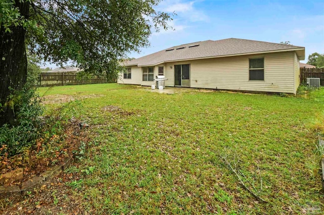 rear view of house with a lawn and cooling unit