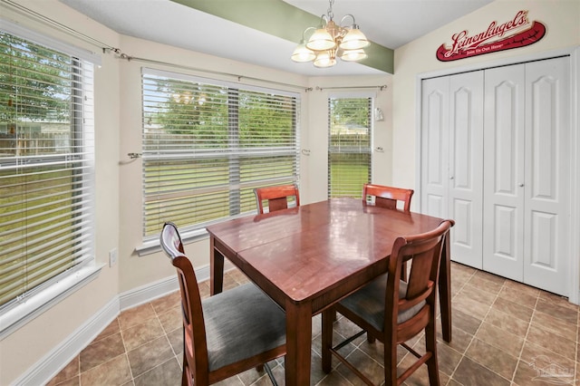 dining space featuring tile patterned flooring, lofted ceiling, and an inviting chandelier