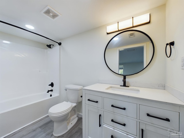 full bathroom with bathing tub / shower combination, hardwood / wood-style floors, vanity, and toilet