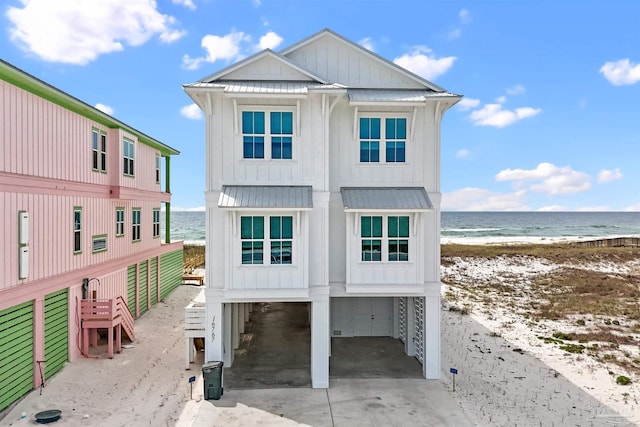 view of front of house with a water view, a view of the beach, and a carport