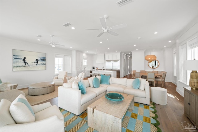 living room featuring sink, ceiling fan, and light hardwood / wood-style floors