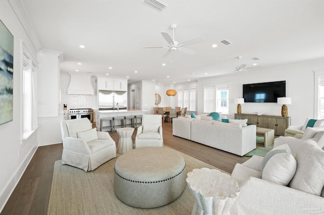 living room featuring crown molding, ceiling fan, and light hardwood / wood-style flooring