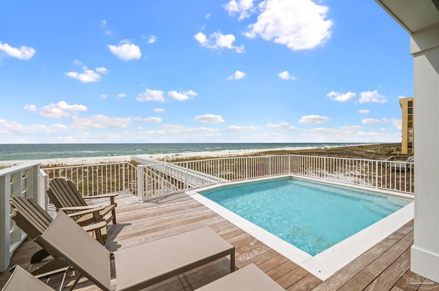 view of swimming pool featuring a deck with water view and a view of the beach