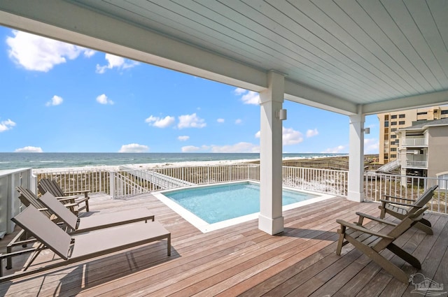 view of swimming pool with a deck with water view and a view of the beach