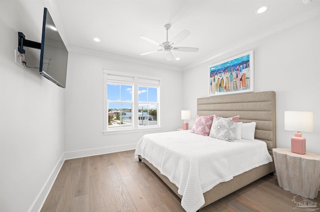 bedroom with ceiling fan, hardwood / wood-style flooring, and ornamental molding