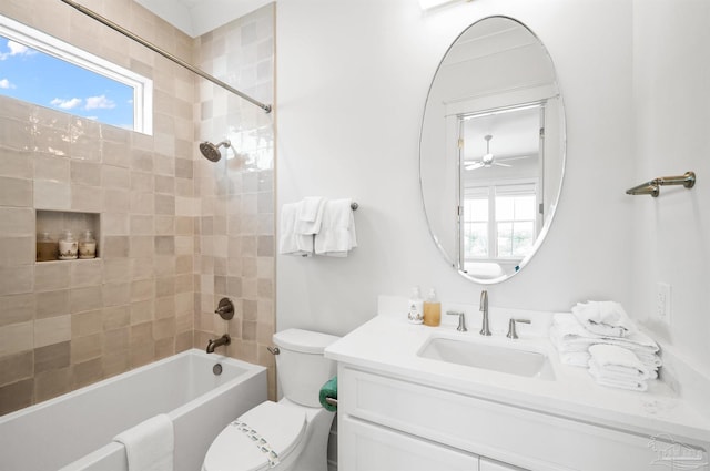 full bathroom with ceiling fan, vanity, tiled shower / bath combo, and a wealth of natural light