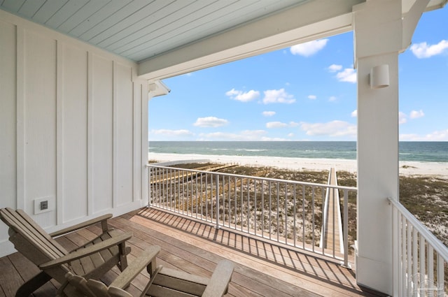 balcony featuring a beach view and a water view