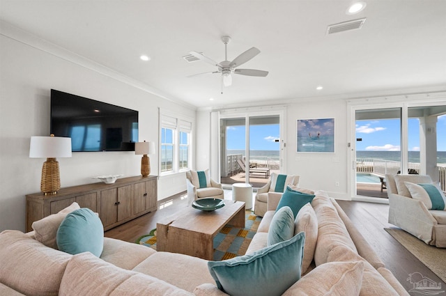 living room with ceiling fan, crown molding, wood-type flooring, and a water view