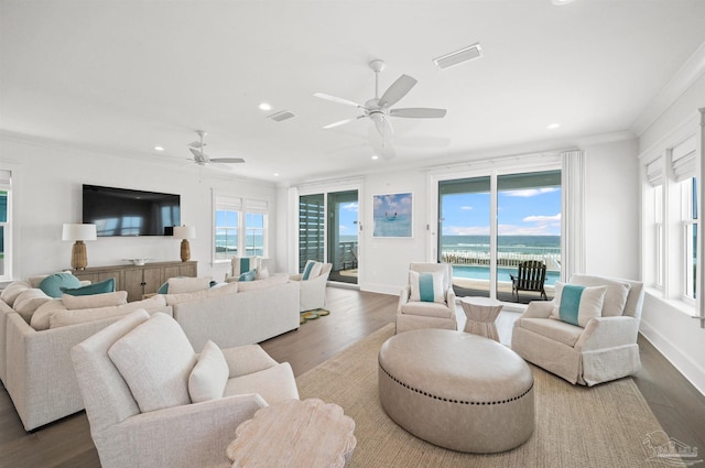 living room with dark hardwood / wood-style flooring, ceiling fan, plenty of natural light, and a water view