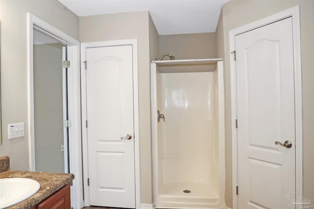 bathroom with a stall shower and vanity