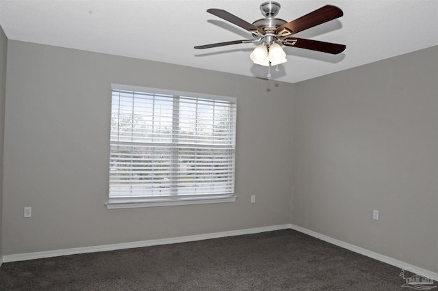 spare room with ceiling fan, baseboards, and dark colored carpet