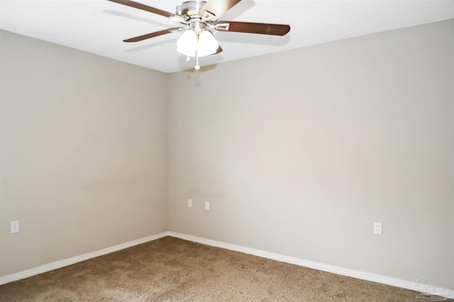 carpeted spare room with ceiling fan and baseboards