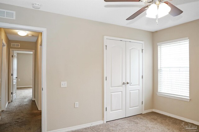 unfurnished bedroom with a closet, carpet, visible vents, and baseboards