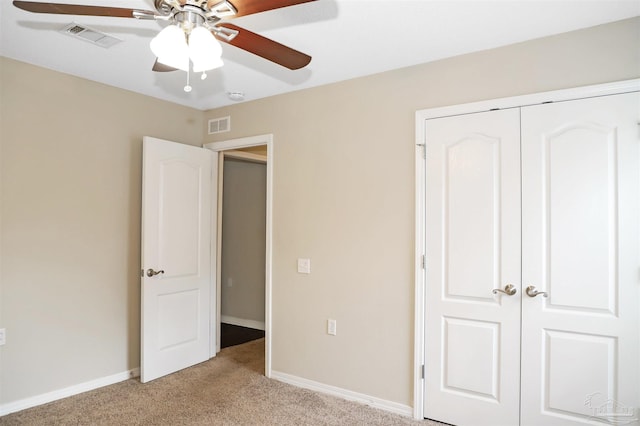 unfurnished bedroom featuring a closet, visible vents, light carpet, and baseboards