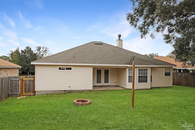 back of property featuring an outdoor fire pit, a fenced backyard, french doors, a lawn, and a chimney