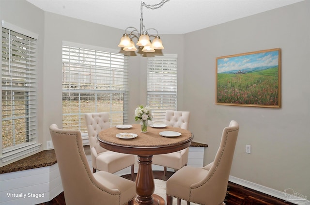 dining space featuring an inviting chandelier, baseboards, and wood finished floors