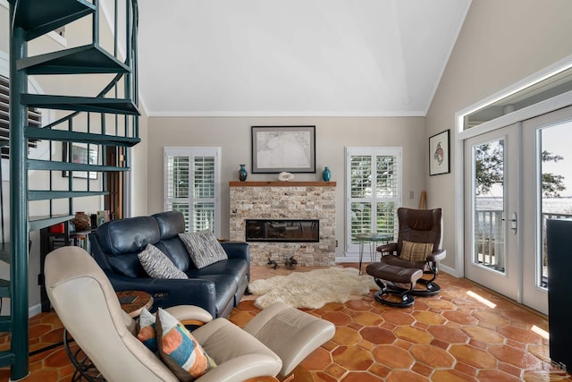 living area featuring baseboards, ornamental molding, vaulted ceiling, french doors, and a fireplace