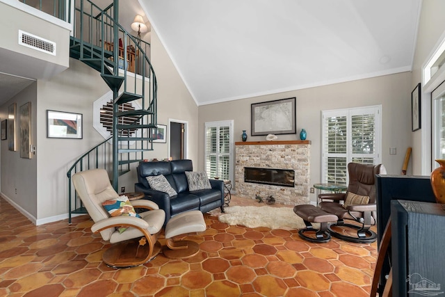 living area with visible vents, a glass covered fireplace, high vaulted ceiling, baseboards, and stairs