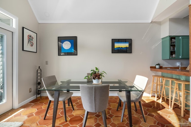 dining space with a wealth of natural light, crown molding, and baseboards