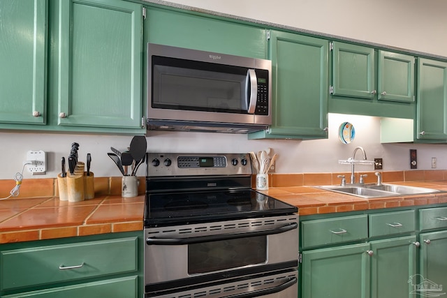 kitchen with stainless steel appliances, tile countertops, and green cabinets