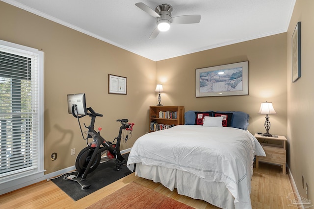 bedroom featuring ornamental molding, a ceiling fan, baseboards, and wood finished floors