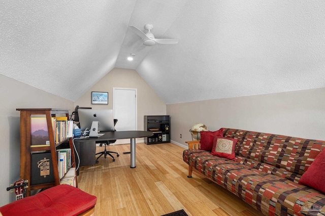 office with baseboards, a ceiling fan, wood finished floors, vaulted ceiling, and a textured ceiling