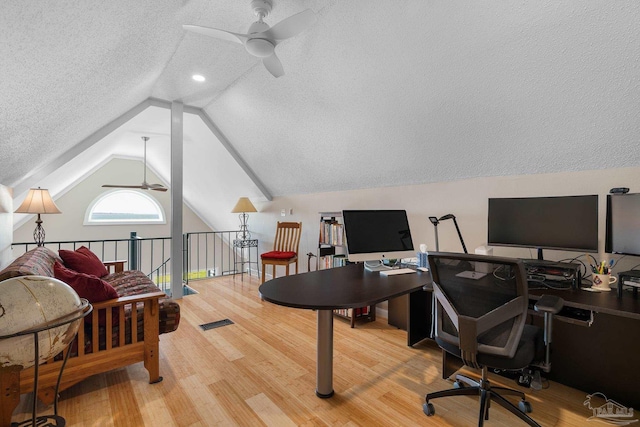 office space featuring lofted ceiling, ceiling fan, a textured ceiling, and wood finished floors